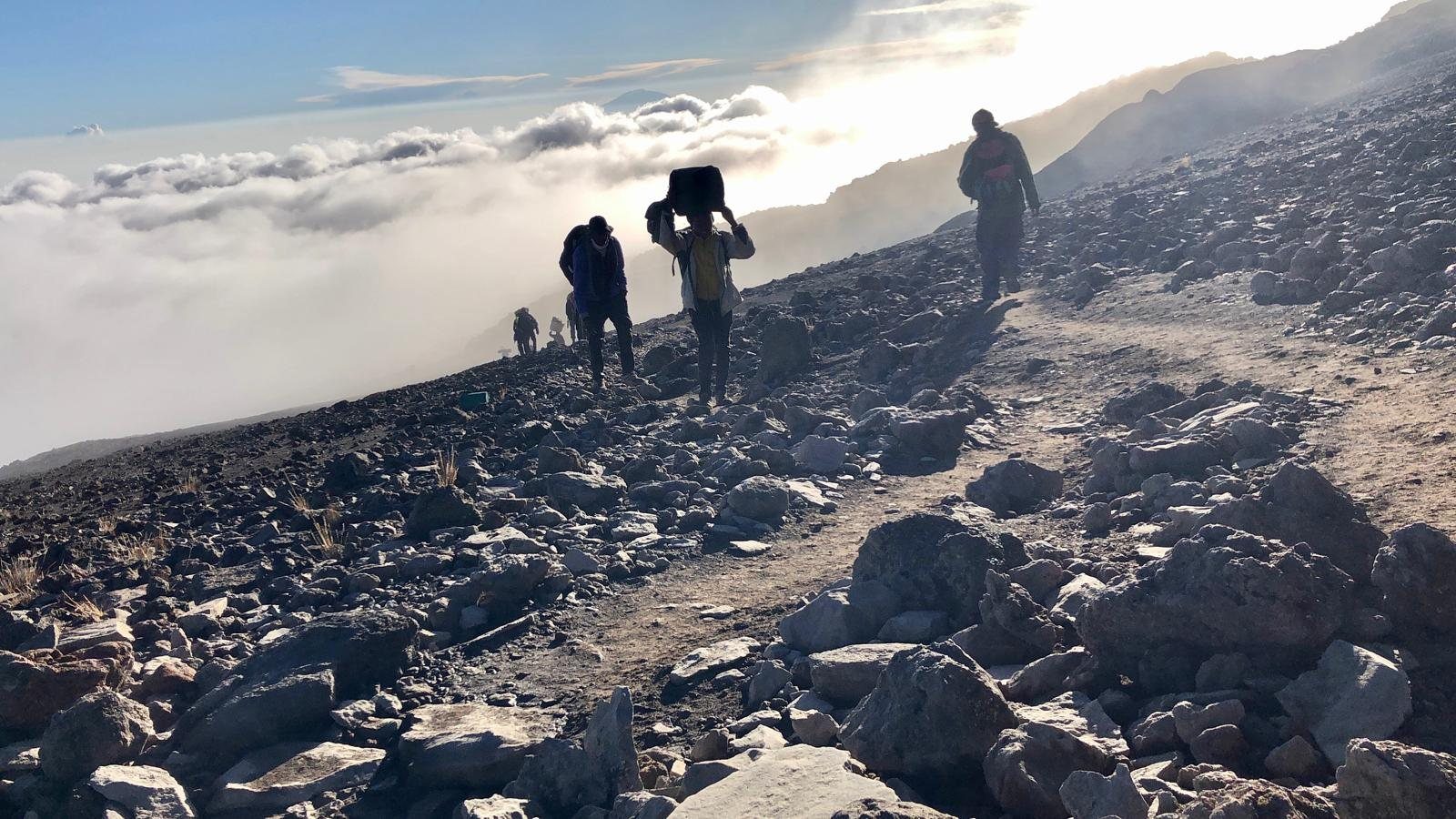Climbers crossing snow and scree near the summit